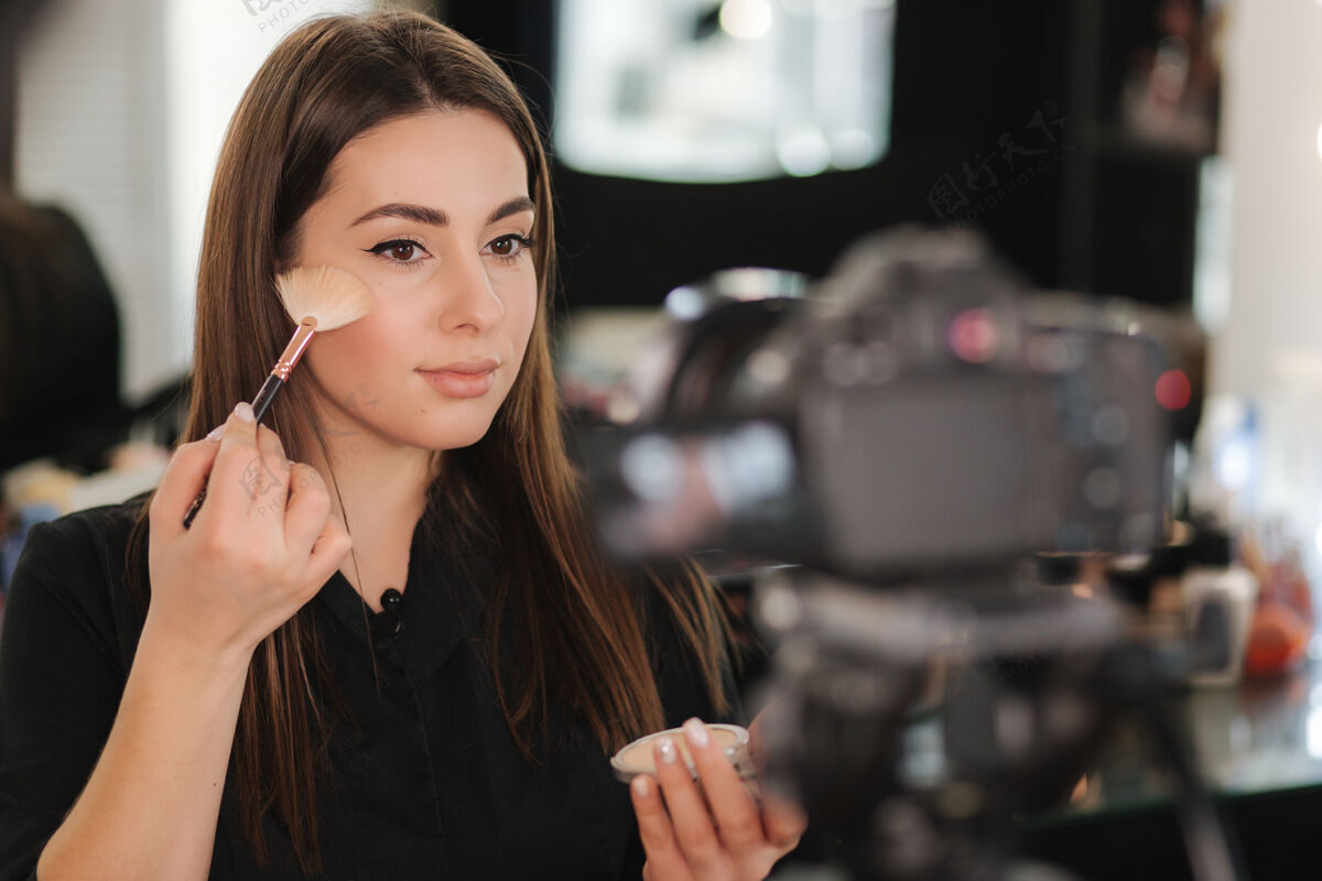 年轻人年轻漂亮的女人和专业的化妆师vlogger录音室化妆教程流化妆数码相机