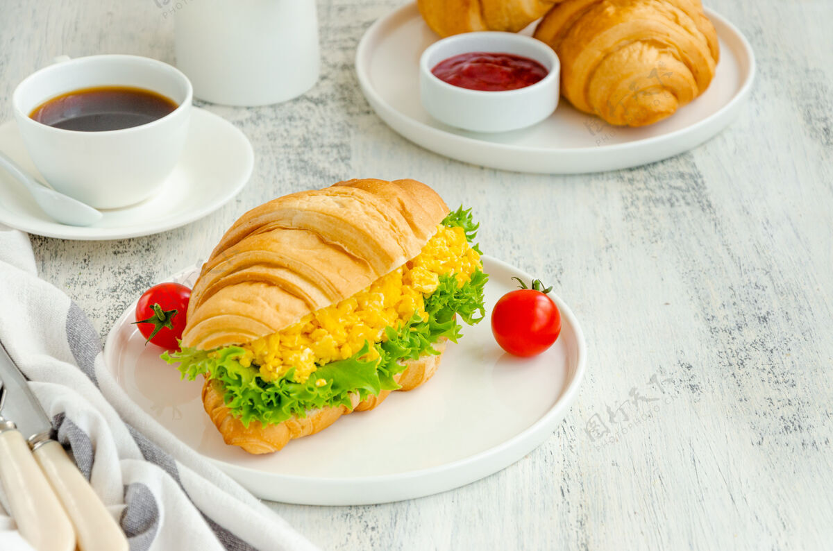 早餐炒鸡蛋 生菜和樱桃番茄羊角面包美味营养生菜