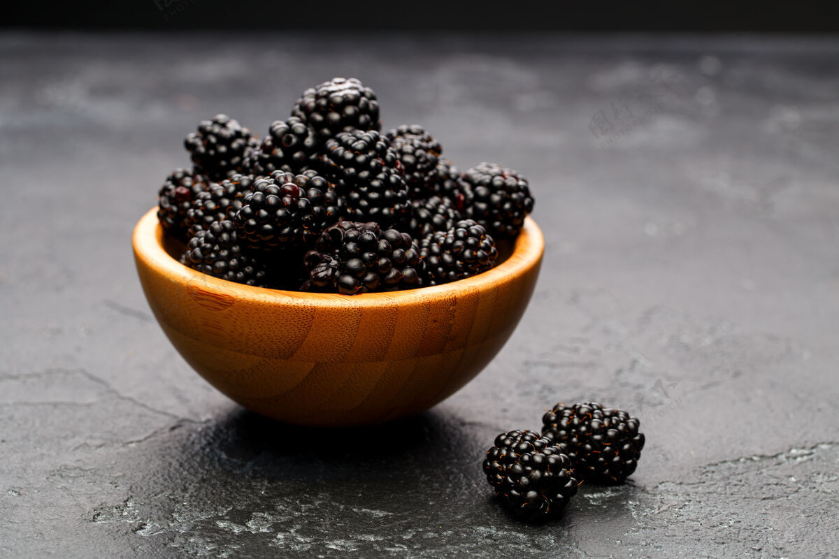 甜照片中的黑莓在木杯在空的黑色背景在工作室粉末素食早餐