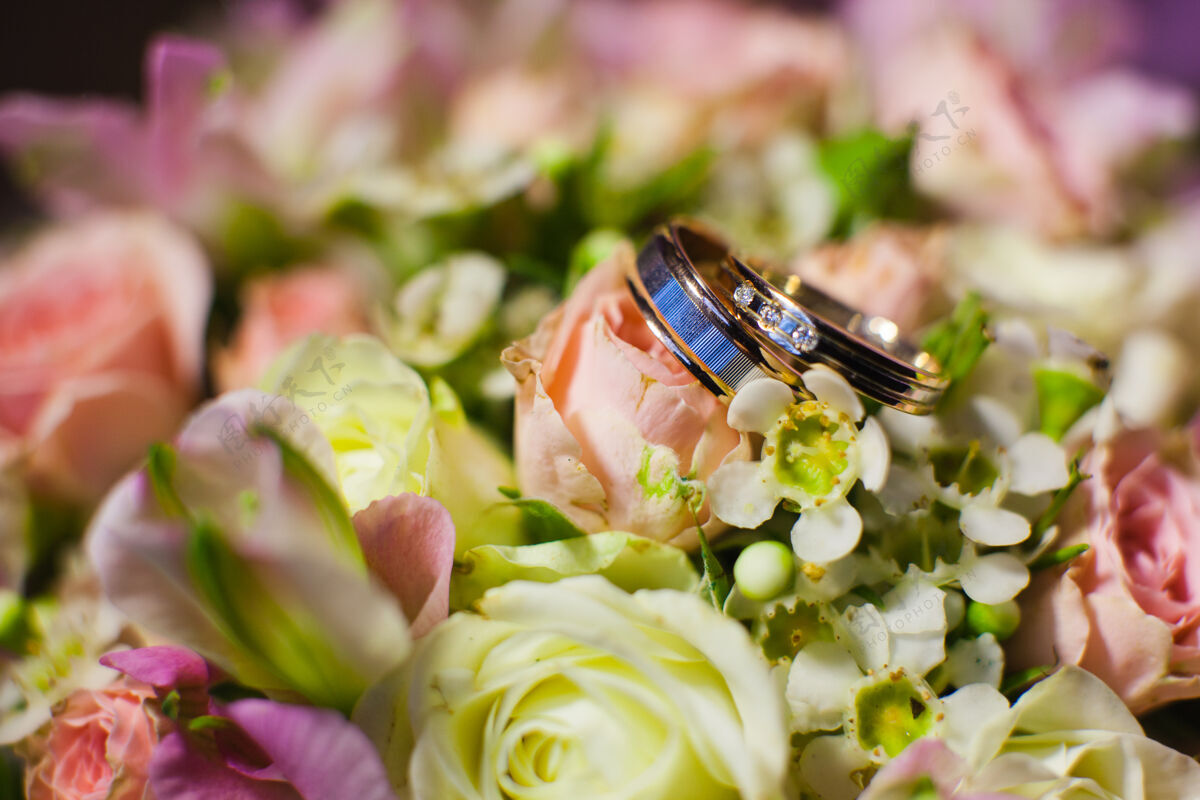 自然粉色的花和两个金色的结婚戒指花美丽庆祝