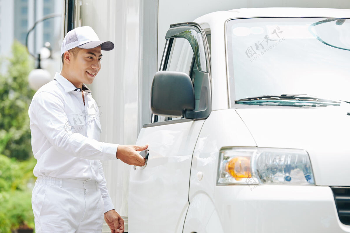 制服帅气微笑的年轻亚洲送货员 穿着白色西装 戴着帽子打开货车门女性男性乳制品