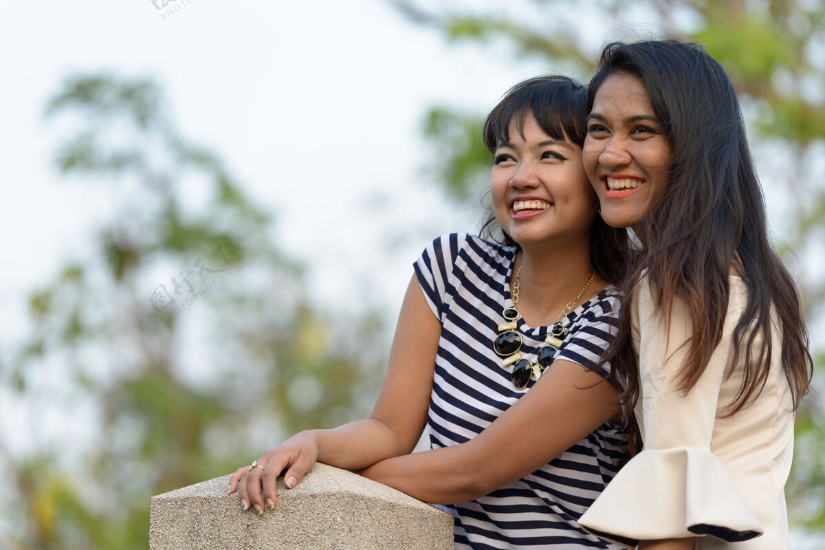 关系两位亚洲年轻女性在公园户外放松的写真爱情思想和平