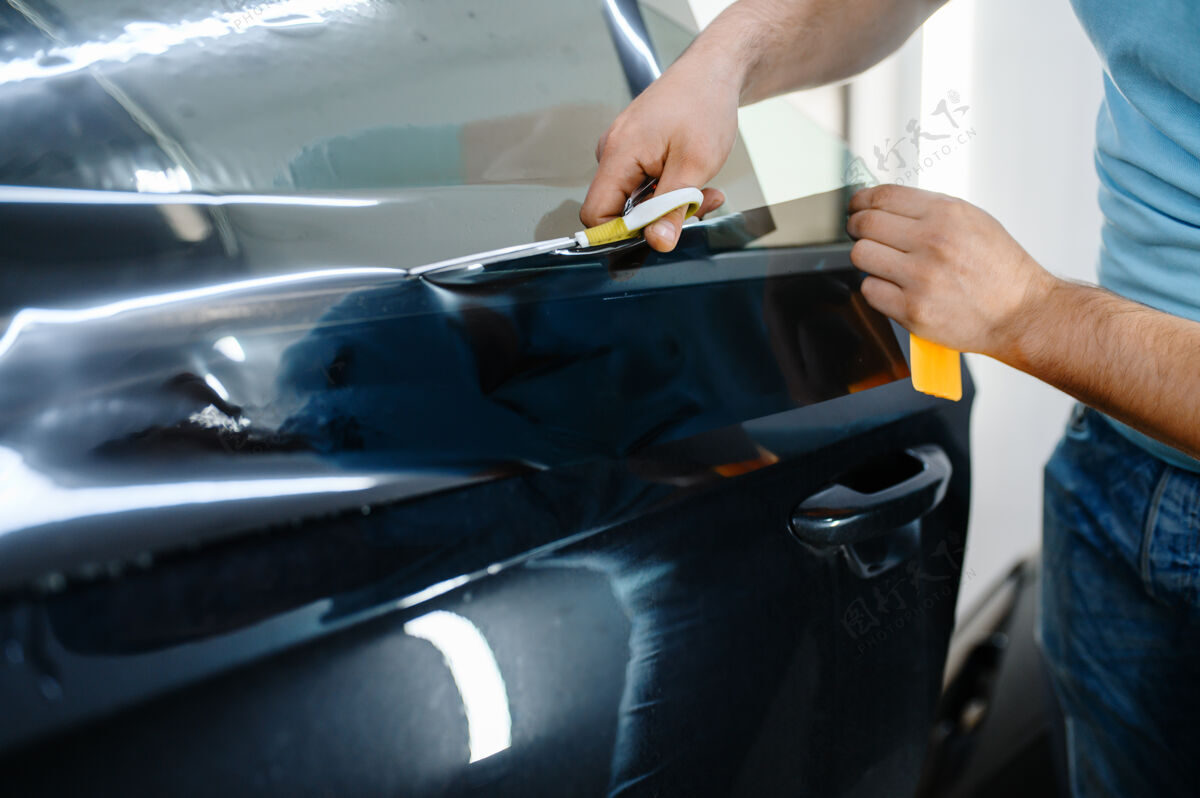 加热男式包装袋 带防晒膜 汽车染色服务工人在车库的车窗上涂乙烯基颜料手专业运输