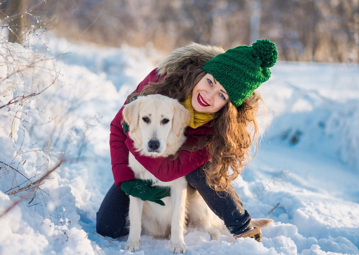户外冬季户外 年轻女孩和她的狗白色金色猎犬拥抱的画面时间.国内宠物女人玩弄狗特写肖像画欢乐金色肖像