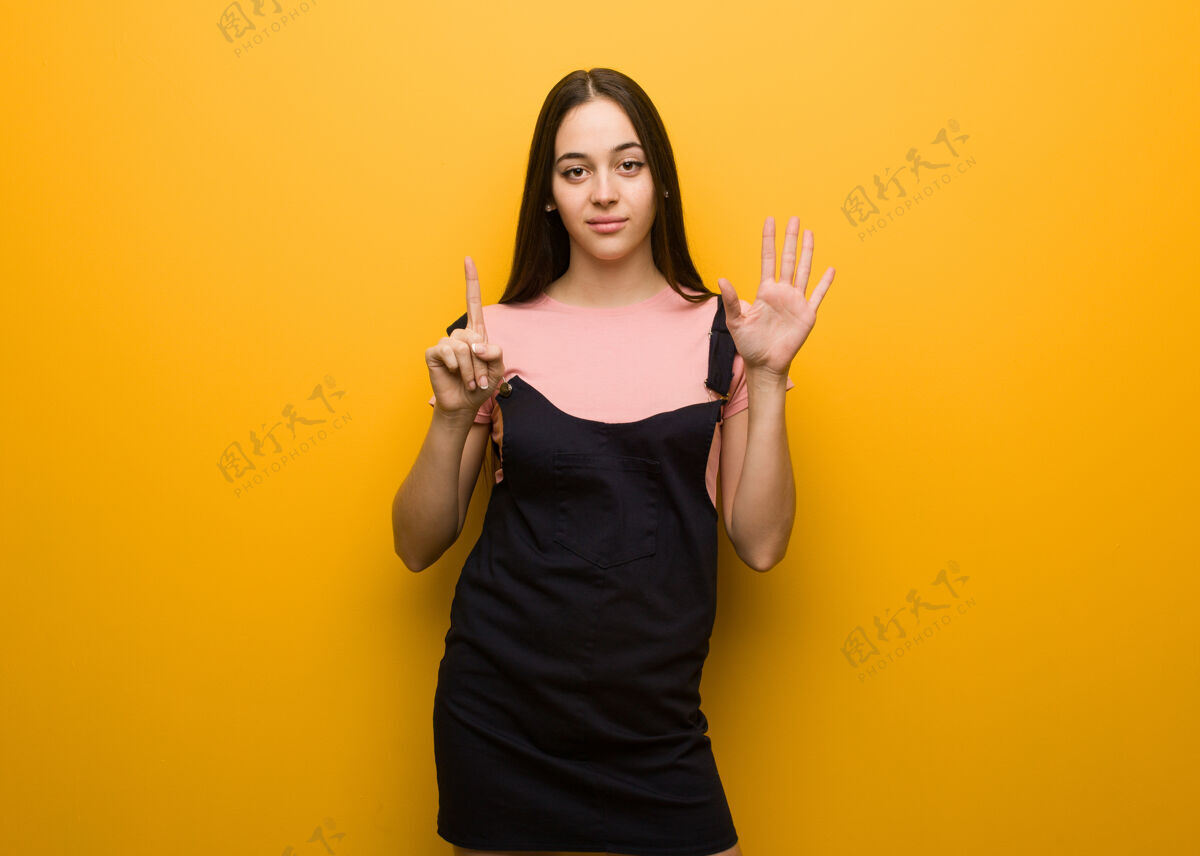 计数年轻的自然漂亮的女人显示第六橙色女性手势