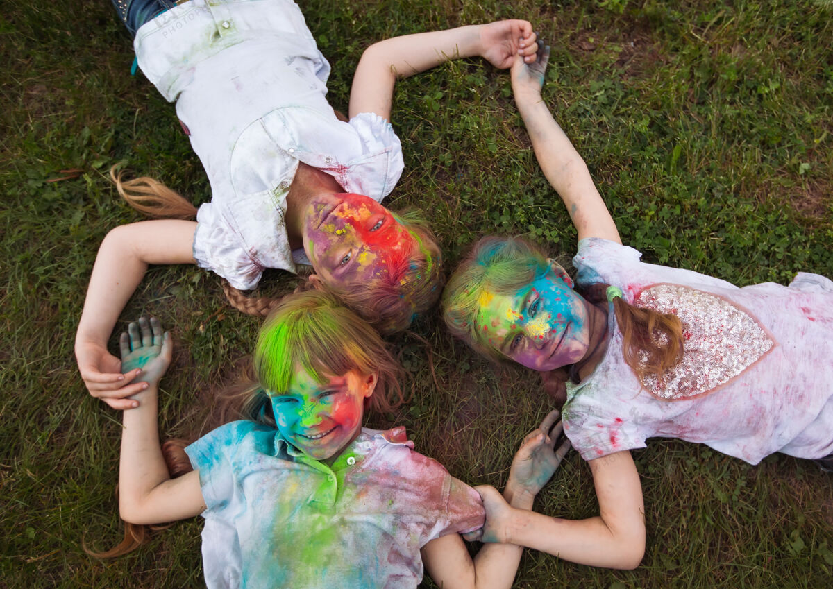 颜色孩子们躺在床上草孩子们画成胡里节的颜色躺在草地上粉玩混乱
