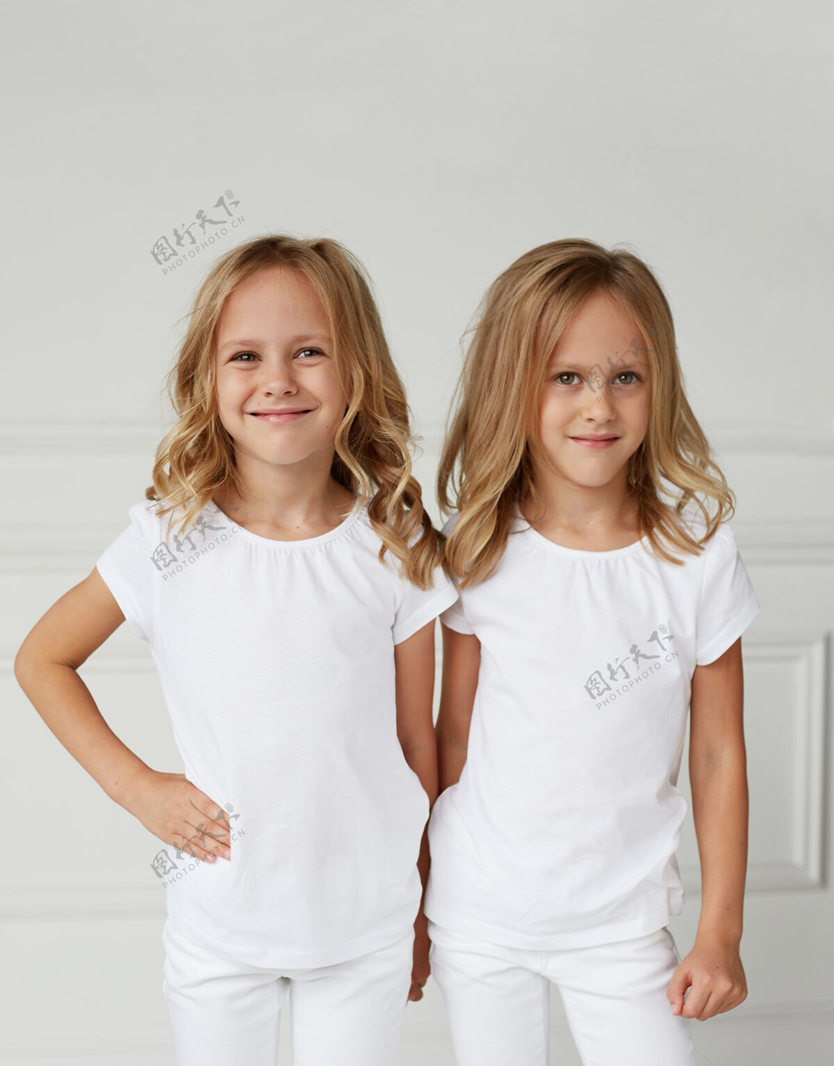 姿势两个穿着白衣服微笑的小女孩时尚金发年轻