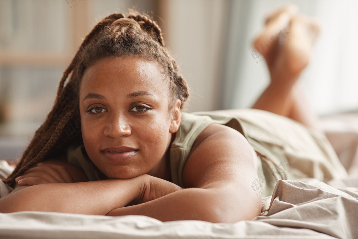 卧室早上躺在床上休息的非洲美女的画像休息棕色头发舒适