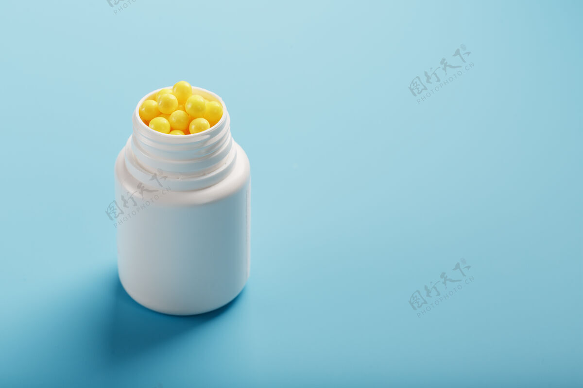 片剂黄色维生素 呈圆形 装在蓝色的白色罐子里背景.健康概念 膳食补充 维生素c免费空间剂量治疗营养