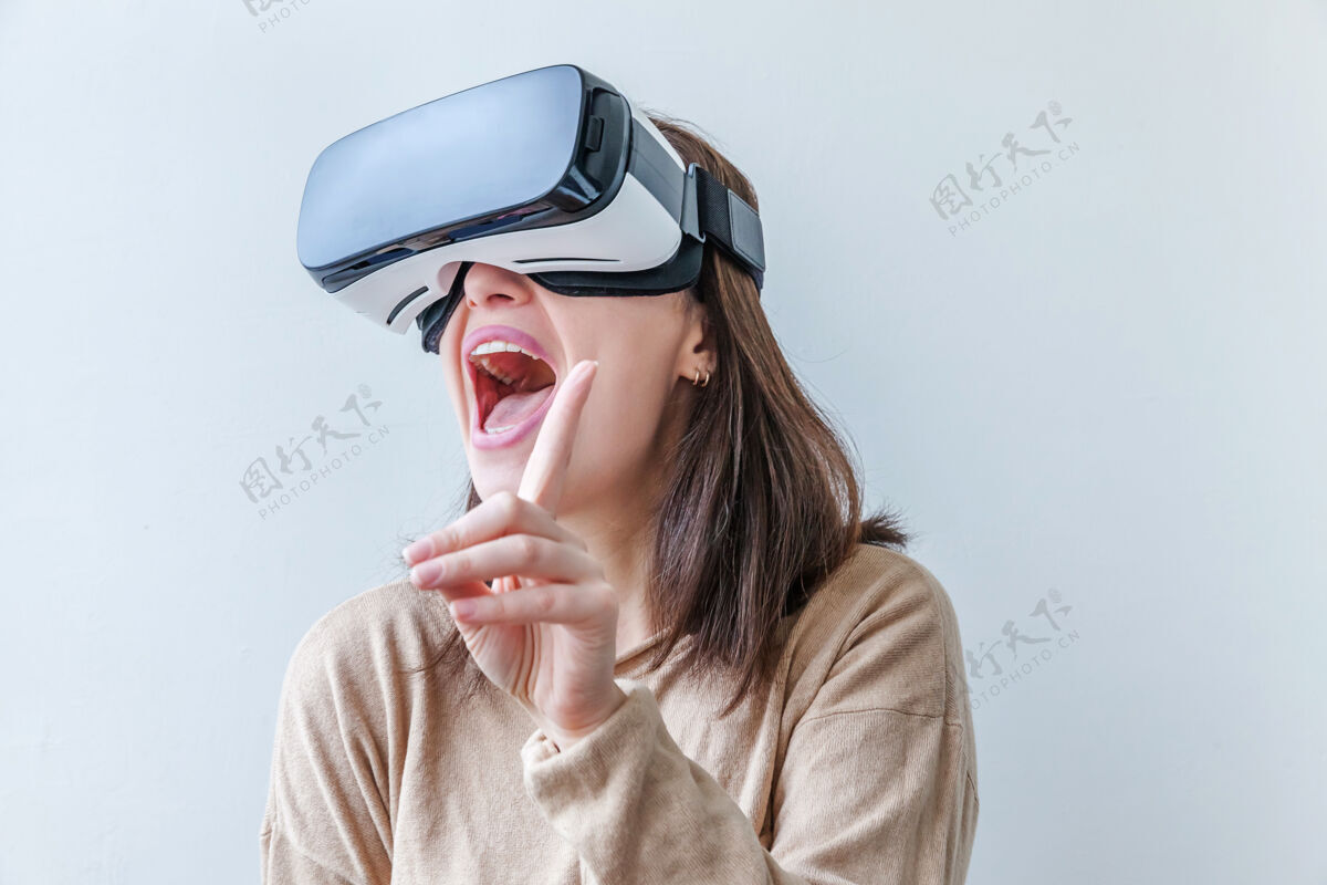 玻璃微笑的年轻女子戴着虚拟现实vr眼镜头盔耳机在白色背景上使用系统模拟