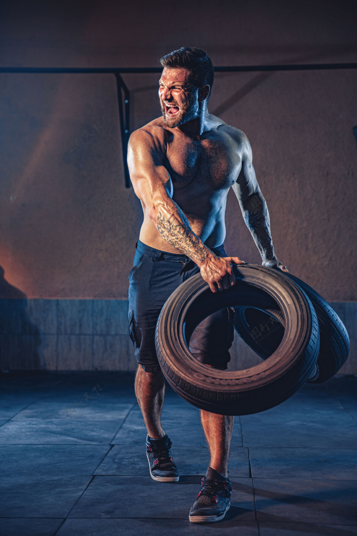 翻转健美训练 大胡子强壮的运动员 肌肉发达的身体举起沉重的轮子在健身房健身年轻身材
