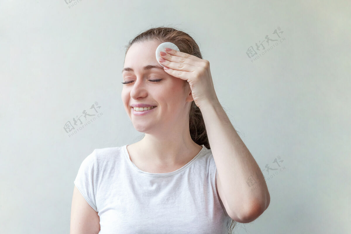 健康美丽的肖像微笑的女人与柔软健康的皮肤卸妆化妆棉隔离在白色背景上水疗棉垫