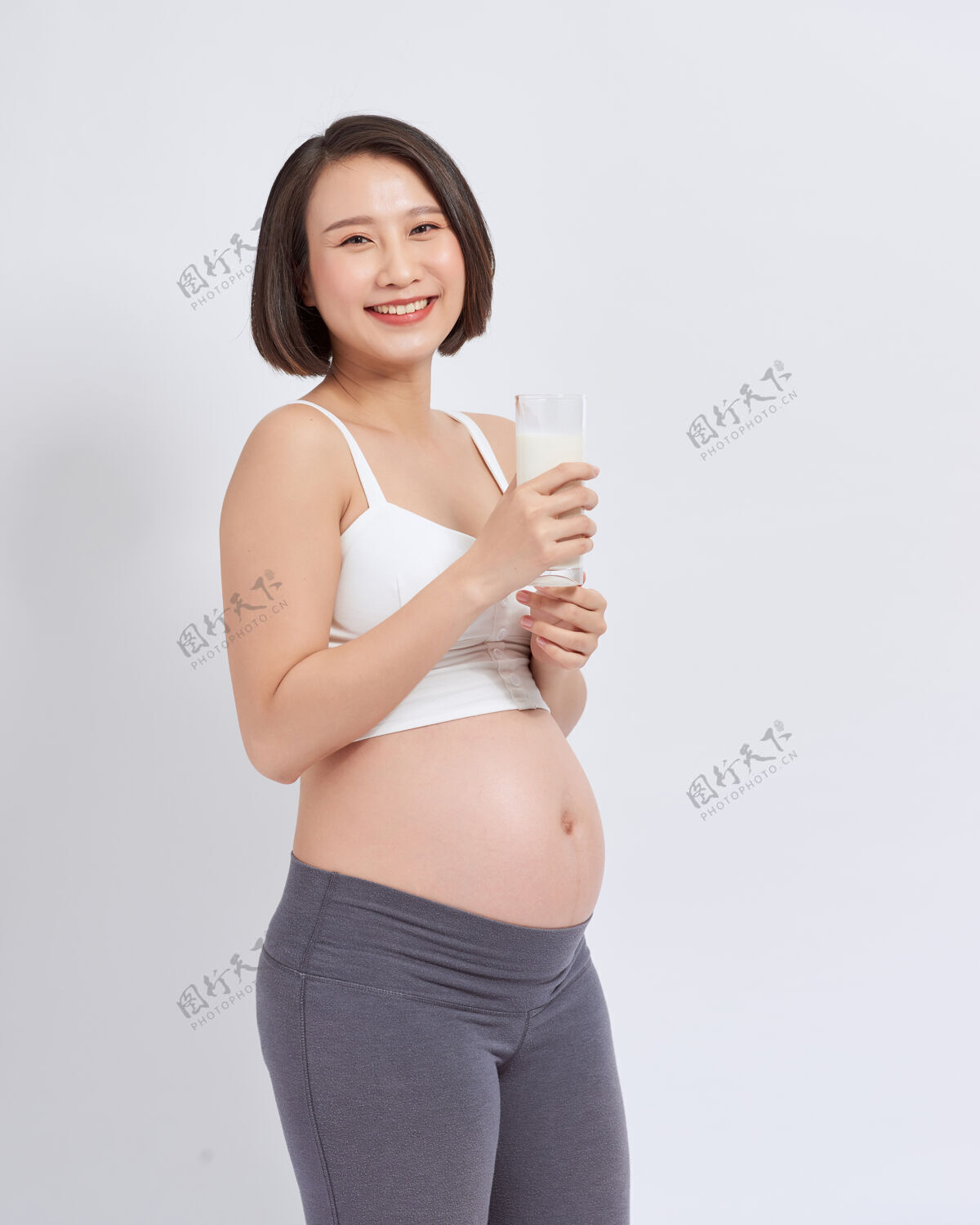 妈妈怀孕的年轻亚洲女人手里拿着一杯牛奶健康女人分娩