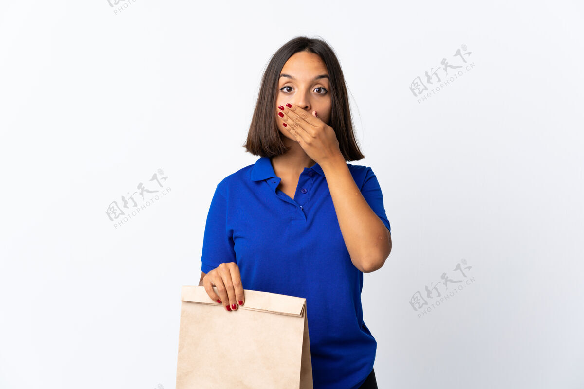 哥伦比亚人一个年轻的拉丁女人手拿着一个杂货店的购物袋 被隔离在白色圆锥形的嘴上健康年轻杂货店