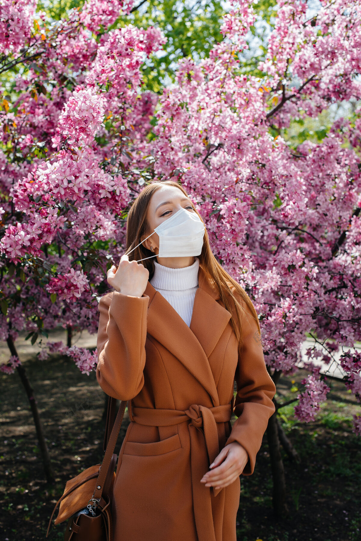 胜利在一个阳光明媚的春日 在盛开的花园前 一个小女孩摘下口罩 深呼吸着流感大流行结束后的气息微笑大团圆结局药