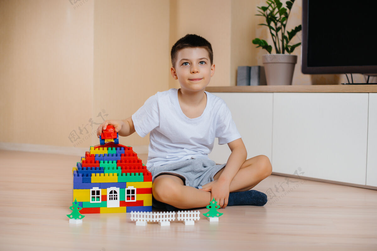 多彩一个小男孩玩着一个建筑工具 为全家建造了一座大房子建造一个家庭住宅创造幼儿建筑
