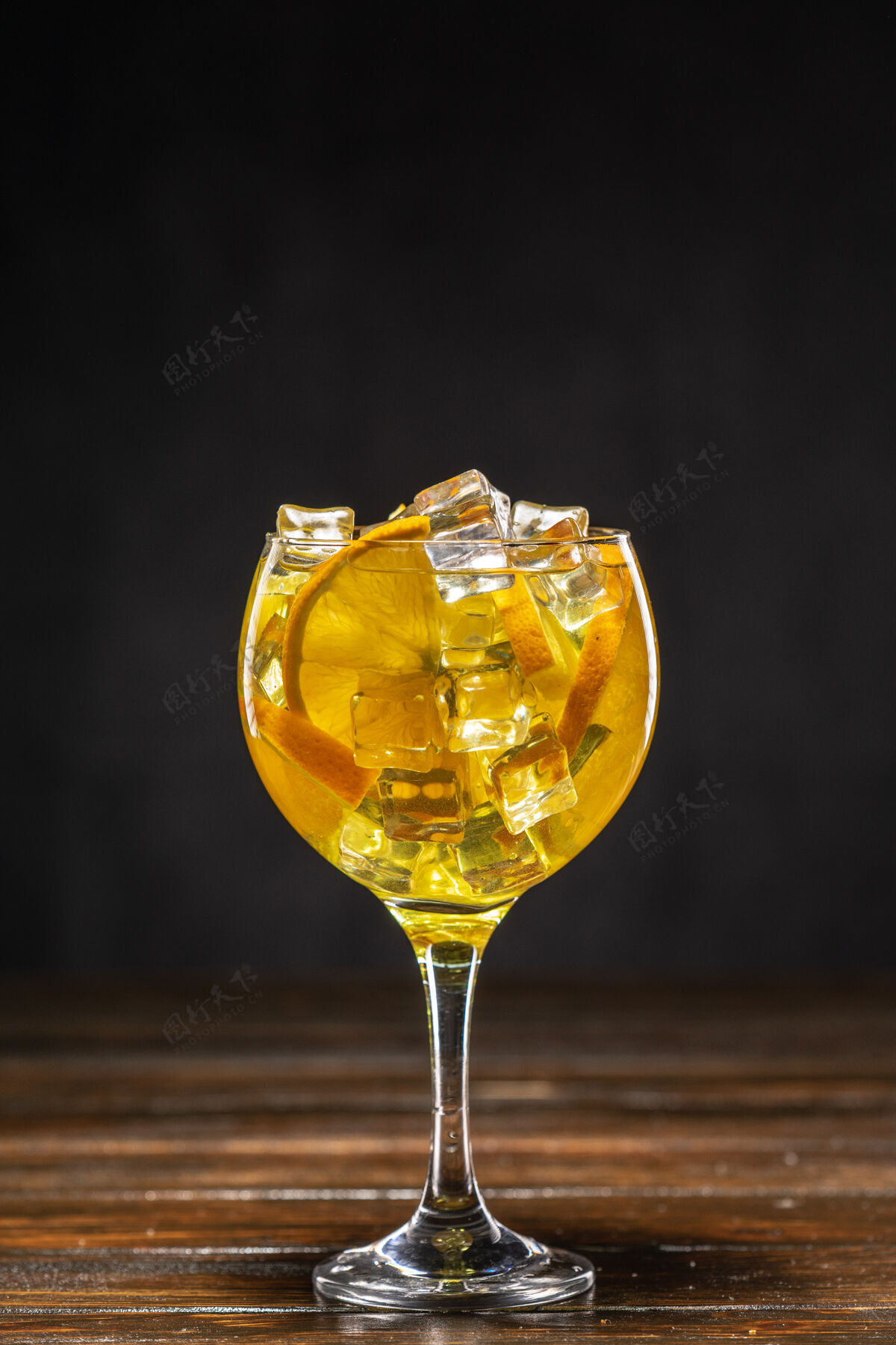 水果加冰块和橙子片的黄色鸡尾酒特写夜总会立方体