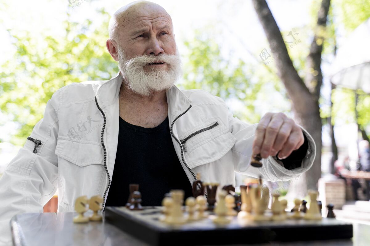国际象棋中枪男子在户外下棋生活方式中杆成人