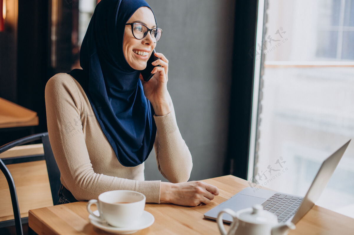 穆斯林女人在咖啡馆里用电脑工作的穆斯林女商人漂亮女人文化