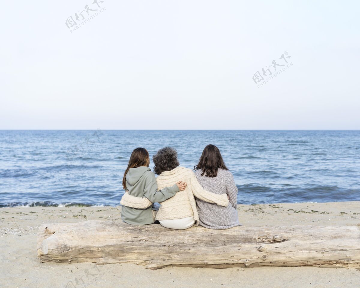 一起妈妈和她的两个女儿一起在沙滩上度过时光外面日志复制空间