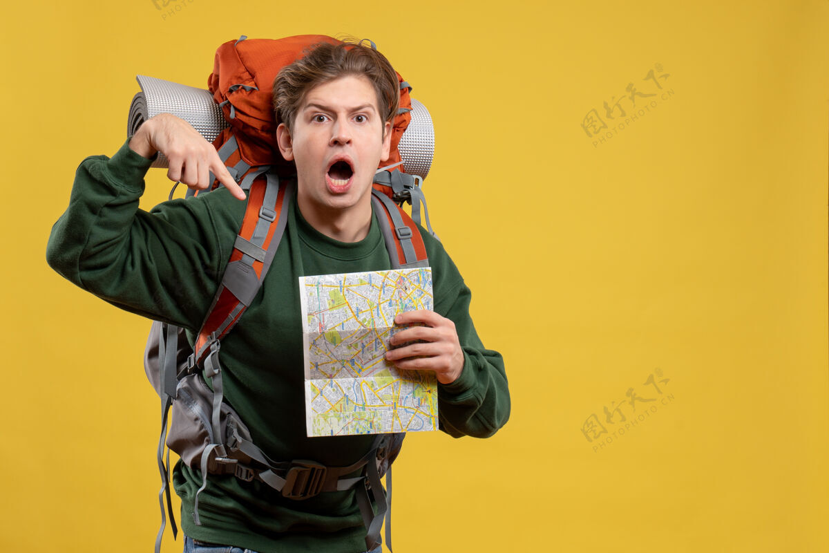 年轻男性正面图年轻男子背着背包拿着地图漂亮旅游持有