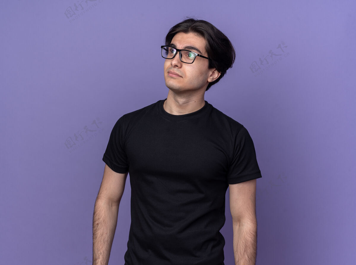 姿势高兴地看着身边年轻帅哥穿着黑色t恤 戴着眼镜孤立在紫色的墙上市民帅气眼镜