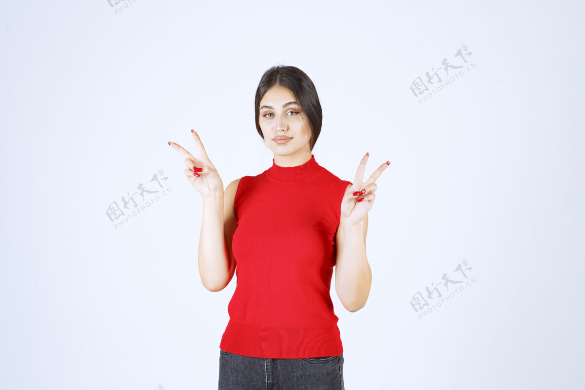 服装穿红衬衫的女孩展示和平和友谊的标志员工人年轻人