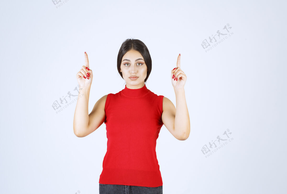 雇员穿红衬衫的女孩举手指着上面人上装年轻