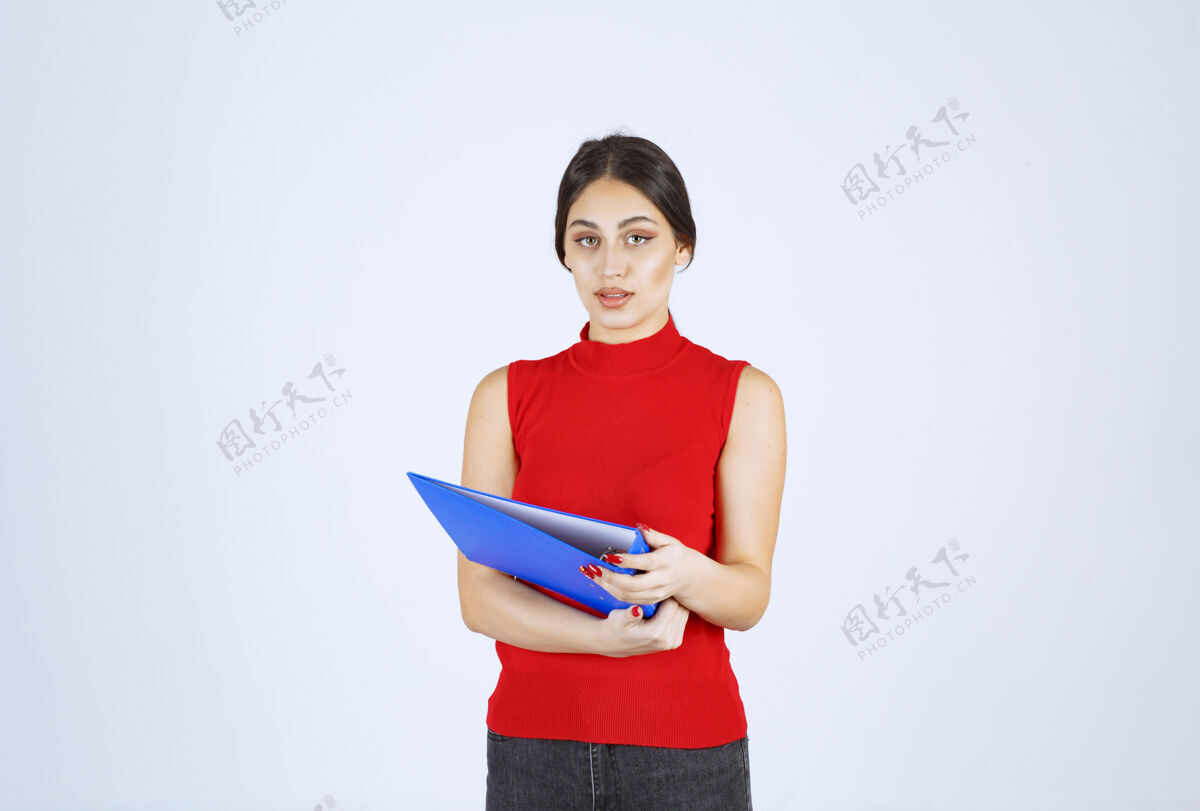 任务穿着红衬衫的女孩手里拿着一个蓝色的商业文件夹职员人类模特