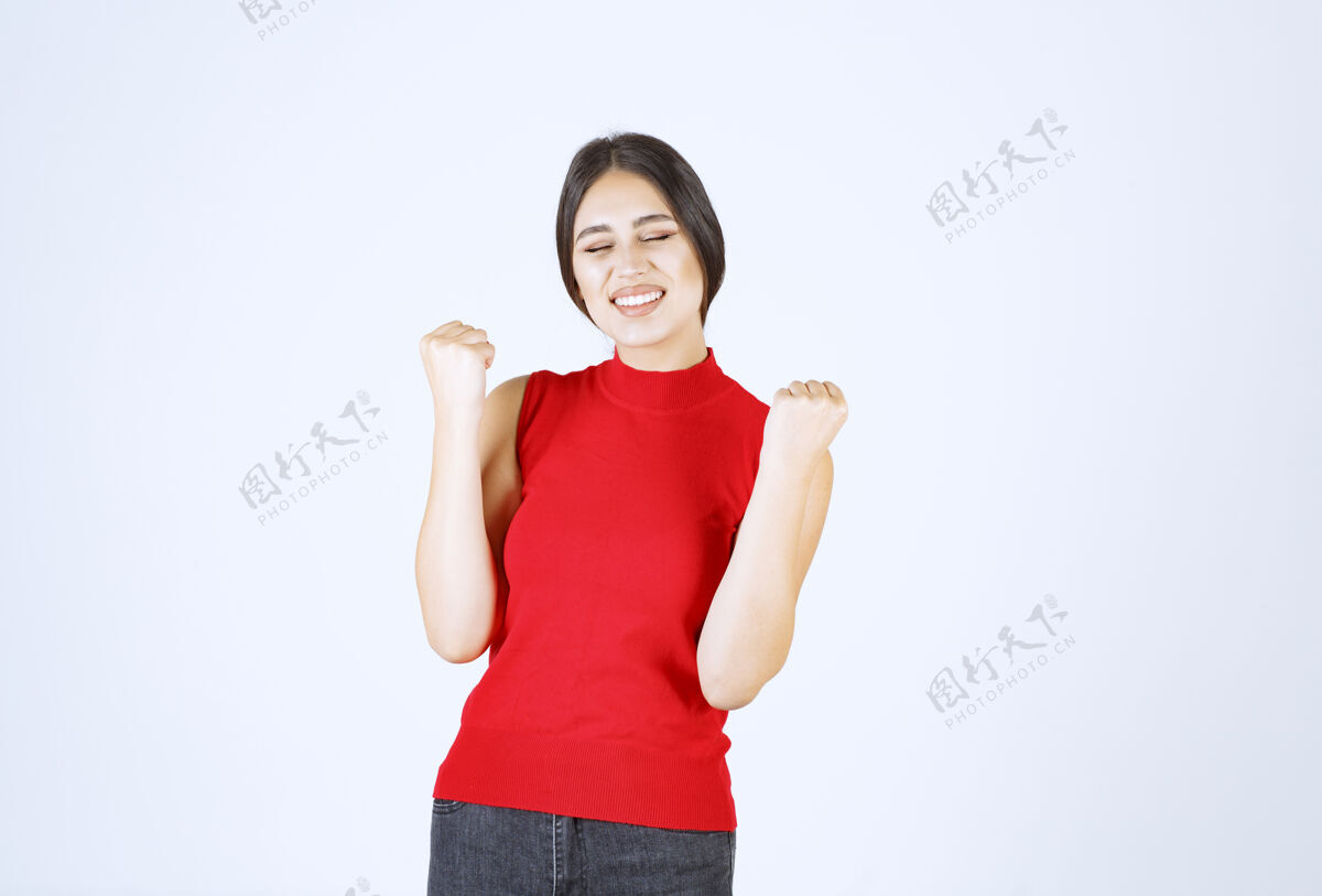 力量穿红衣服的女孩伸出拳头 感觉很成功工人年轻休闲