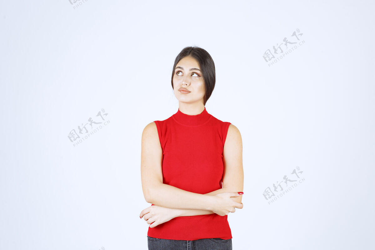 工人穿红衬衫的女孩摆出中性 积极和吸引人的姿势年轻女人诱惑
