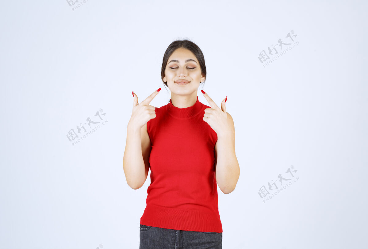 年轻人穿红衬衫的女孩指着她的微笑员工嘴巴年轻人