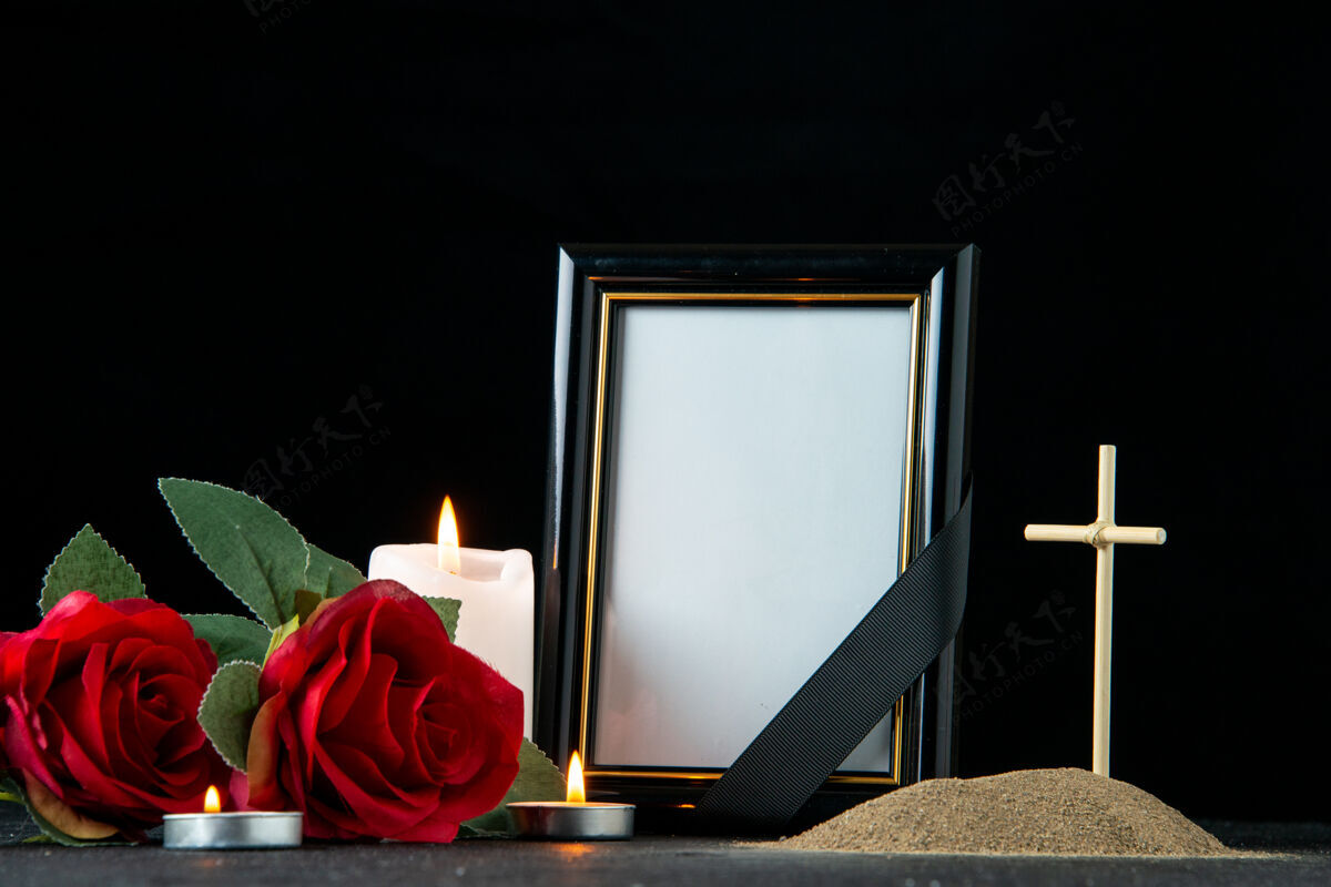 空白黑暗中 鲜花和蜡烛点缀着小坟墓的正视图葬礼玫瑰花