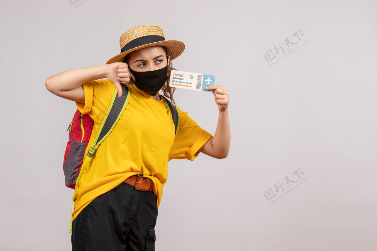 度假正面图背着背包的年轻旅客举着车票做着拇指朝下的手势人按住旅游