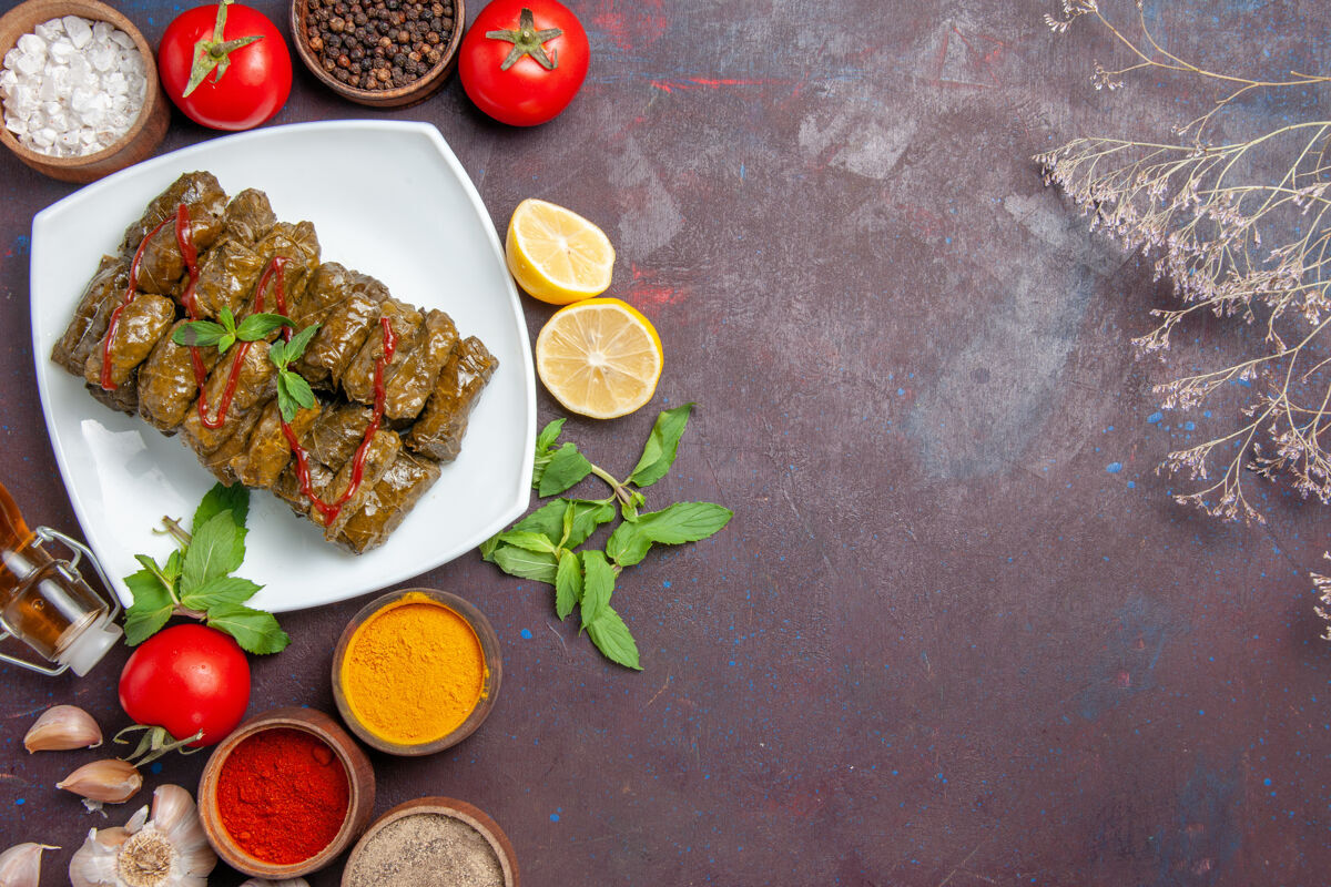 晚餐俯瞰美味的叶杜尔玛与不同的调味品和番茄对黑暗的背景肉菜叶食品晚餐食物顶部调味品