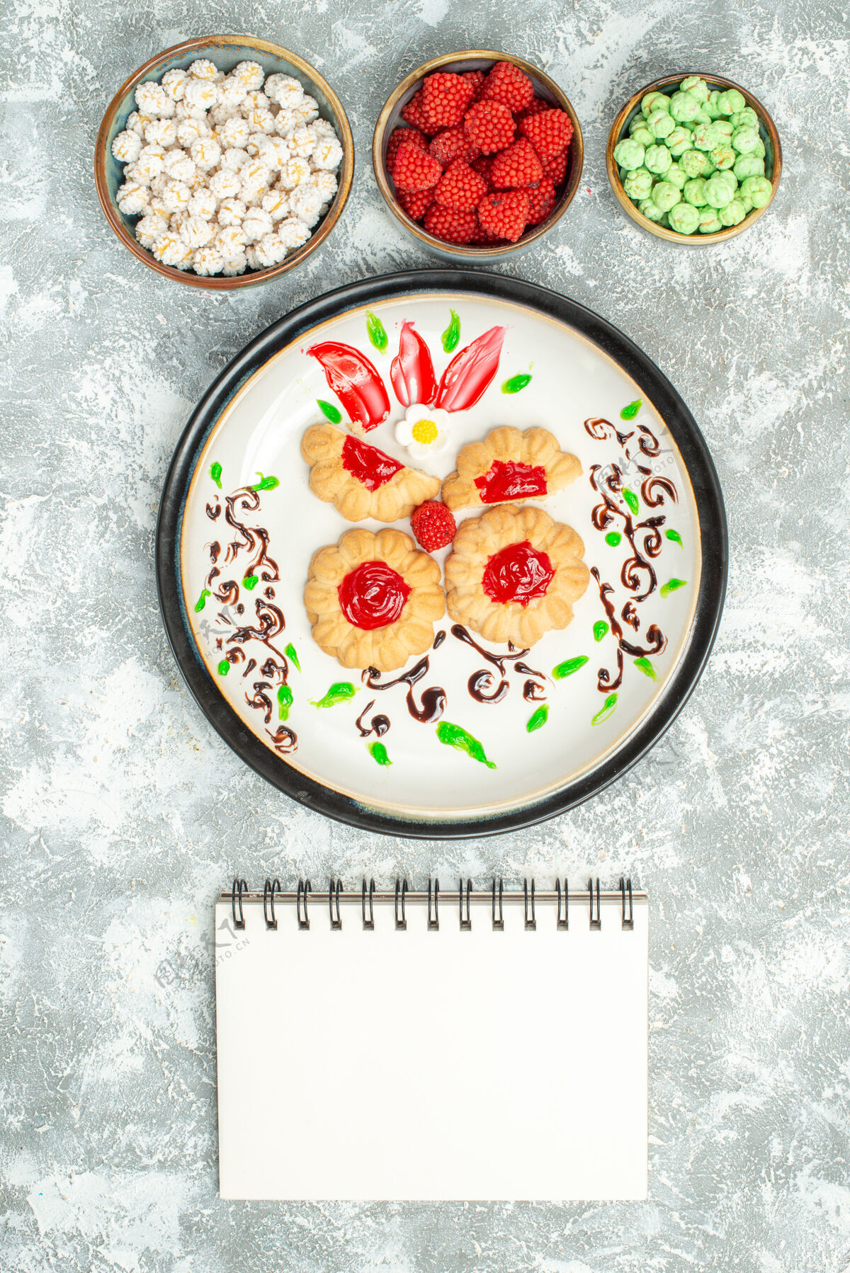 容器俯瞰美味的饼干与红色果冻和糖果的白色背景饼干蛋糕饼干甜茶美味饼干用餐果冻