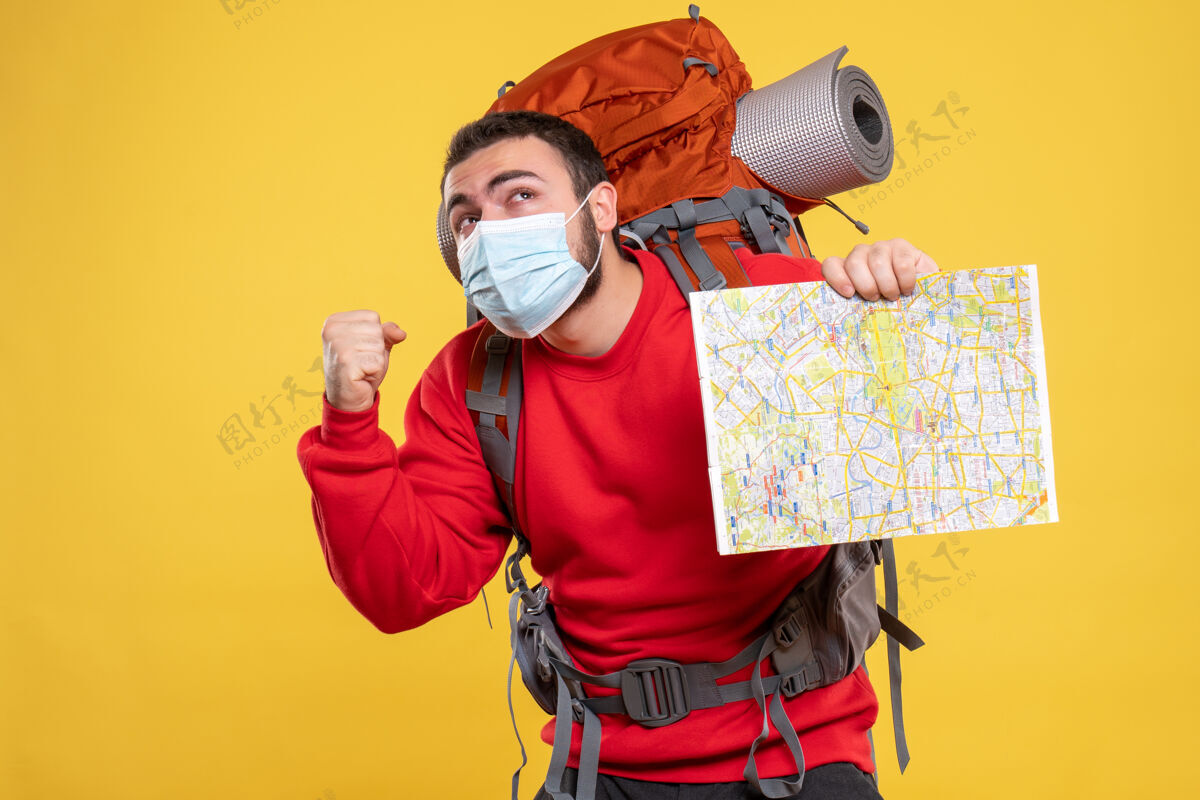 表情上图是一个情绪化的旅行者 他戴着医学面具 背着黄色背景的地图设备手持人物