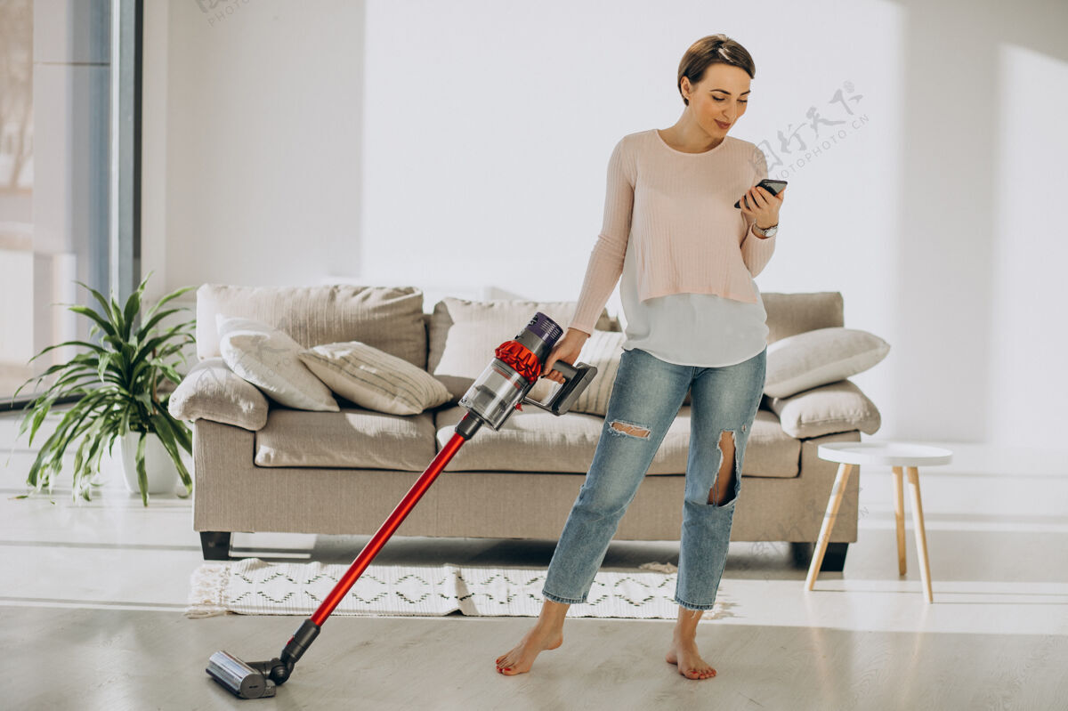 家政年轻女子用可充电吸尘器在家清洗家用清洁设备