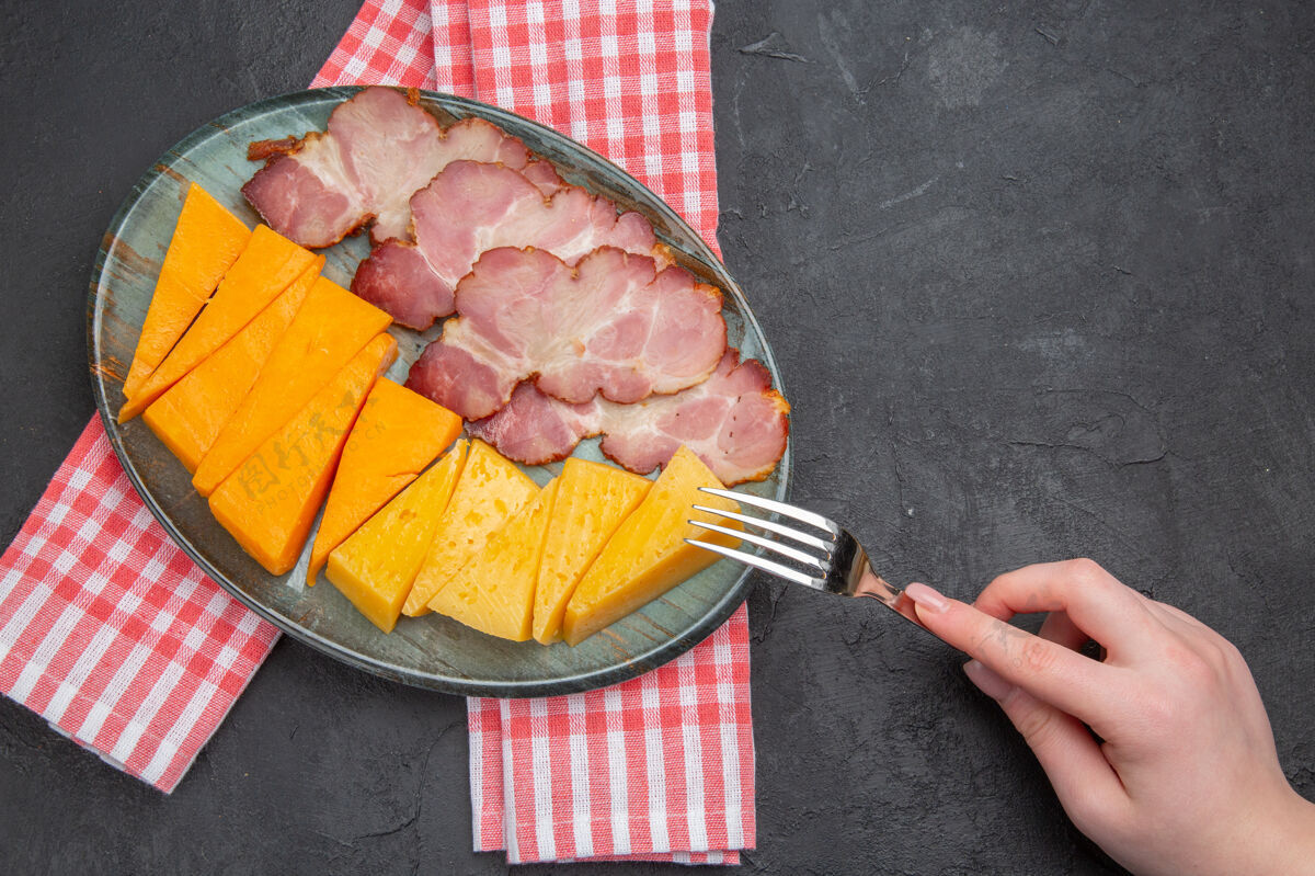 切肉刀上图：手拿叉子放在蓝色盘子里 红色半折毛巾上放着美味的小吃餐巾食品叉子