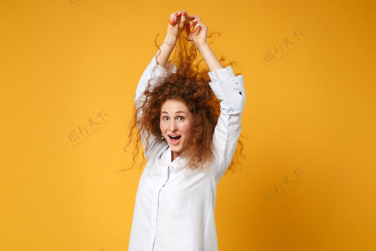 红发震惊的年轻红发女子穿白衬衫的女孩在黄橙色的墙上摆出孤立的姿势一个休闲苍蝇