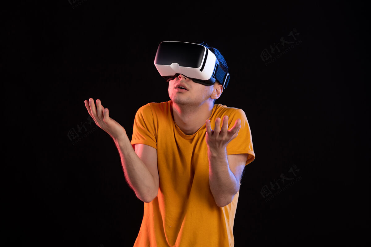 视觉年轻男性在黑暗的墙上玩虚拟现实的画像男性人物黑色