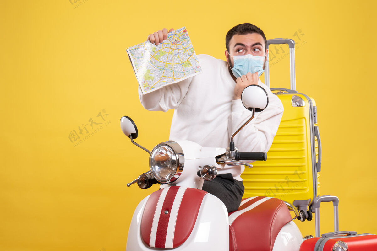 男人旅行概念的俯视图 戴着医用面罩的年轻人站在摩托车旁边摩托车顶医疗