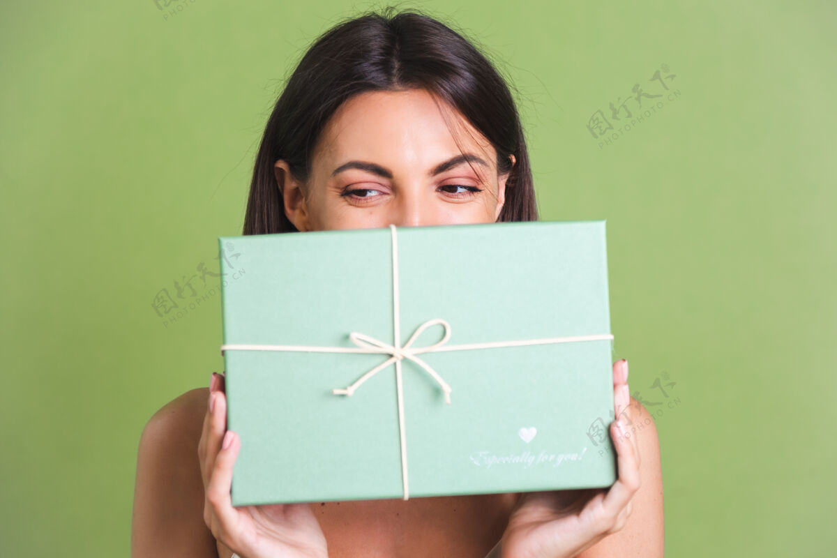 华丽手持绿色礼盒的年轻女子圣诞节盒子节日