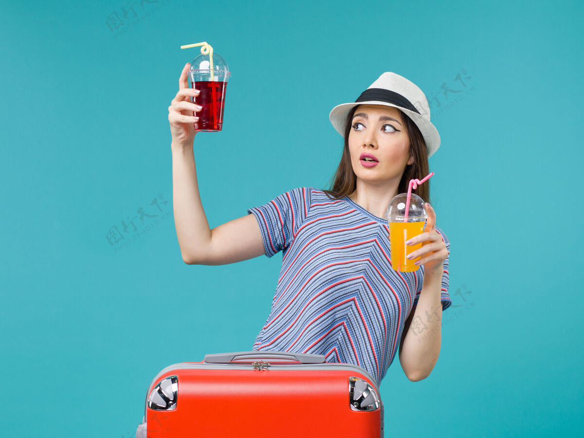 举行度假的女人拿着蓝色的新鲜饮料航行果汁女人