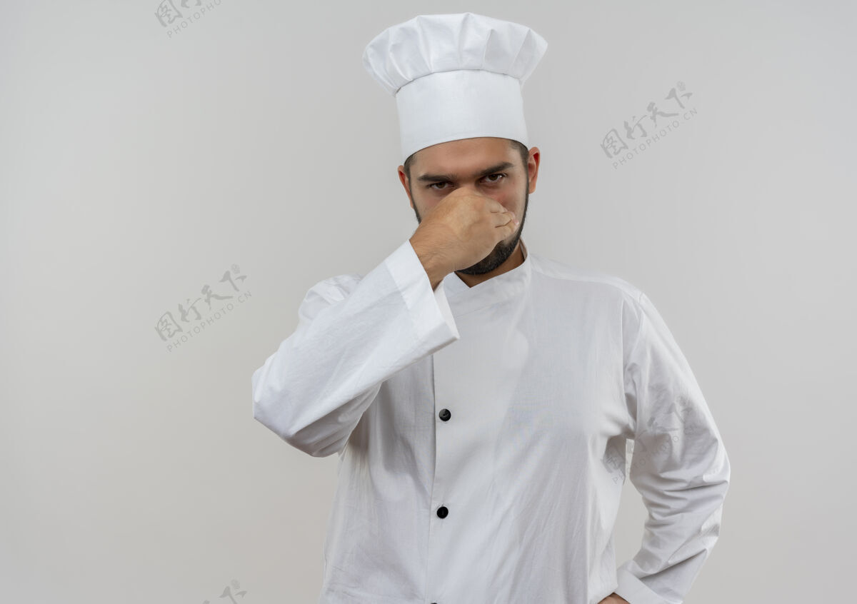 年轻恼怒的年轻男厨师穿着厨师制服 鼻子被隔离在白色墙壁上 留有复印空间厨师鼻子抱着