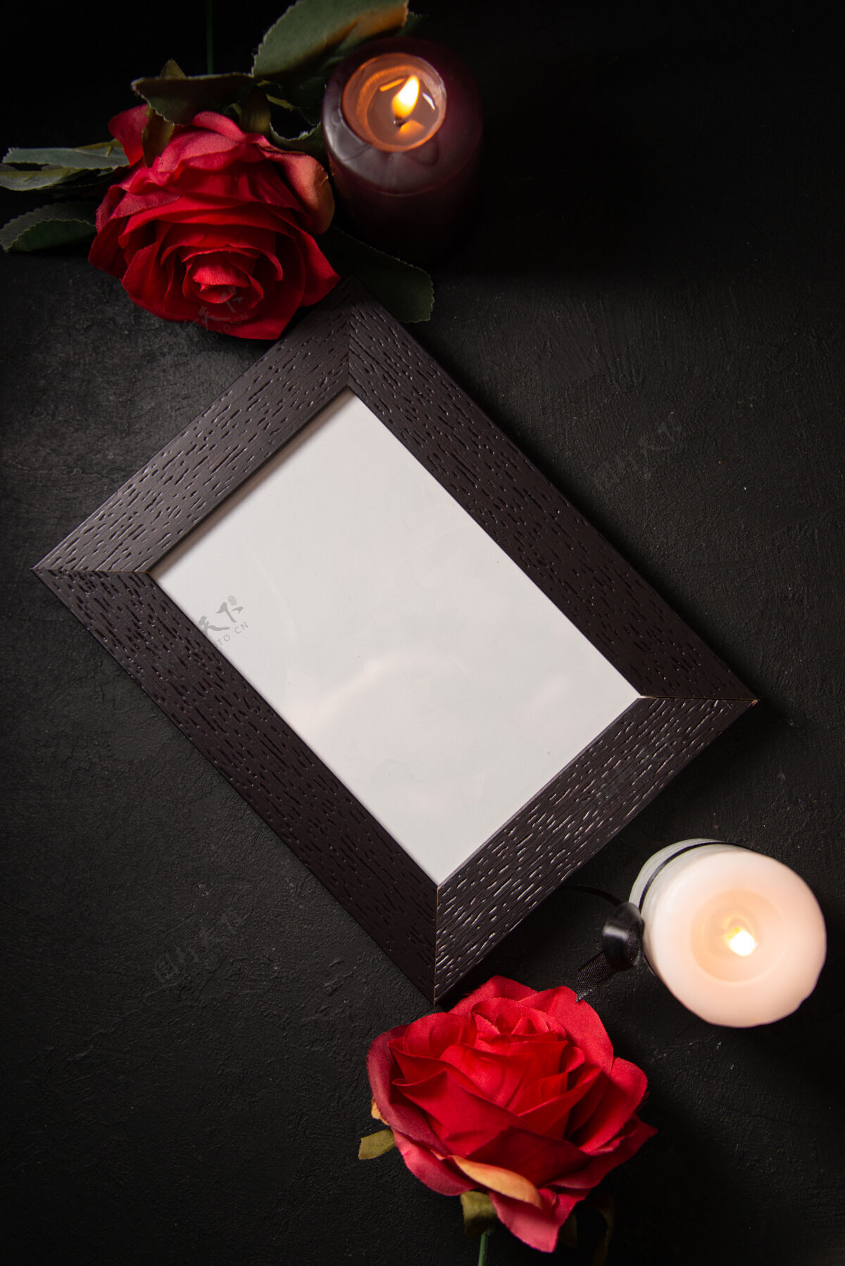空黑色墙上有红花的相框顶视图空白葬礼红