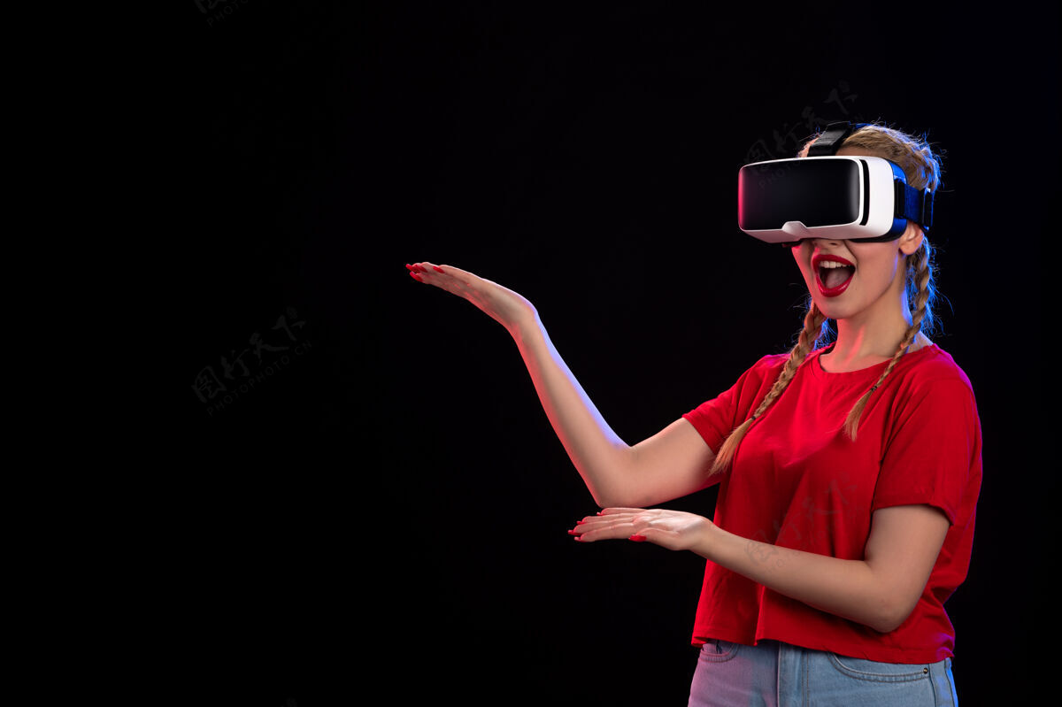 视觉年轻女性在黑暗的墙上玩虚拟现实的正面图黑色虚拟现实女士
