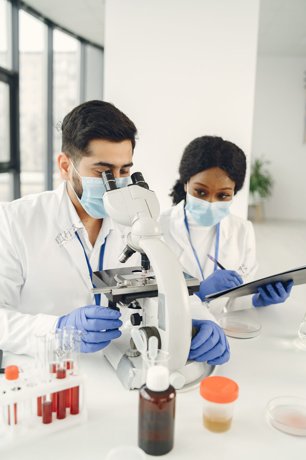 生物化学新试验集中技术人员穿制服做试验 制造疫苗疫苗显微镜检查