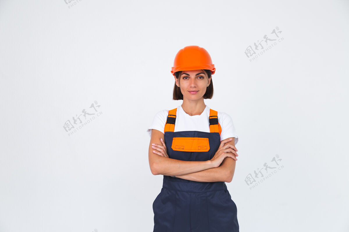 女士漂亮的女工程师戴着白色的防护头盔自信地微笑着交叉双臂手势复制空间自信