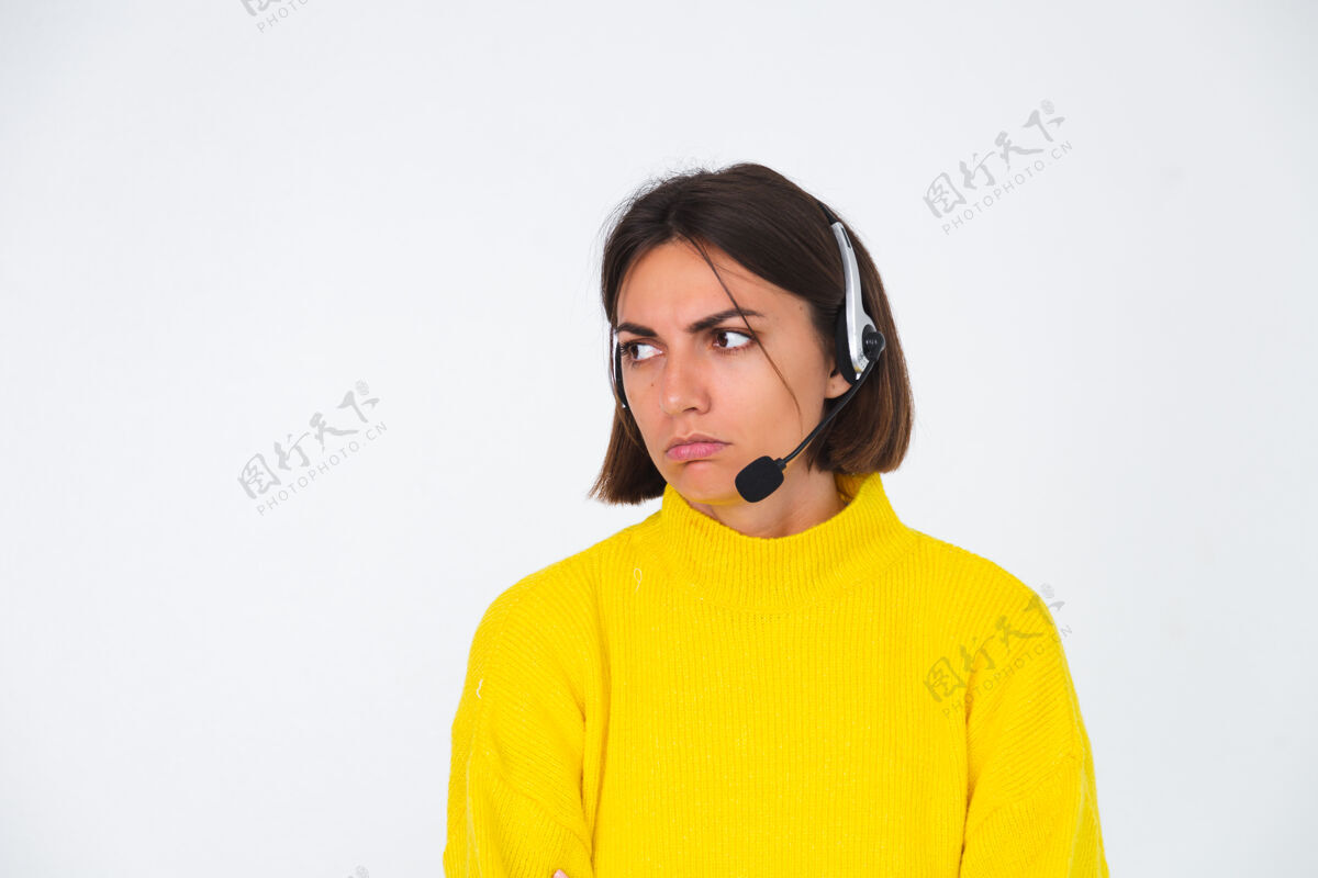 客户穿黄色毛衣的漂亮女人戴着白经理的耳机不开心累无聊争论愤怒女性